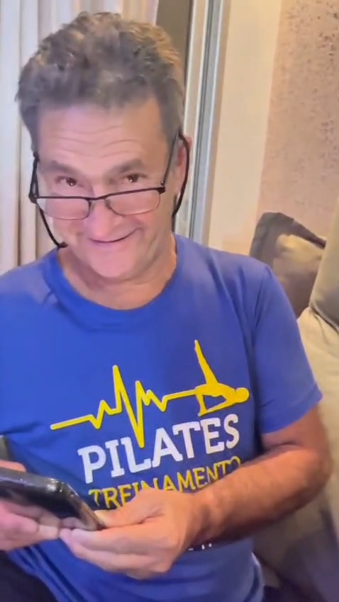 Homem sorrindo ao começar a assistir uma homenagem